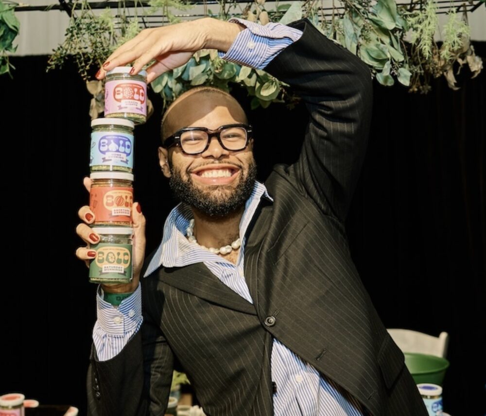 Vendor holding a stack of BOLD spice jars